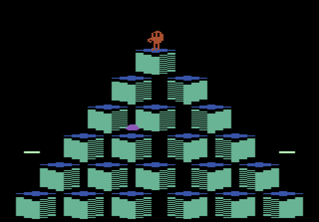 Q*bert on the 2600: Q*bert hopping on a flat-coloured pyramid of cubes, with a ball bouncing down from the top